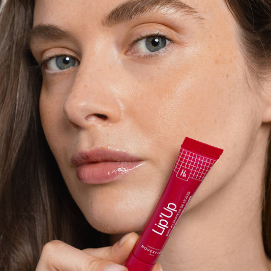 Woman holding a red 'Lip Up' product close to her face