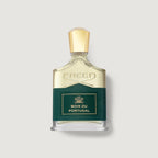 A bottle of Creed Bois du Portugal perfume, featuring a clear glass bottle with pale gold liquid, a textured dark green label with gold lettering, and a faceted gold cap, set against a light gray background.