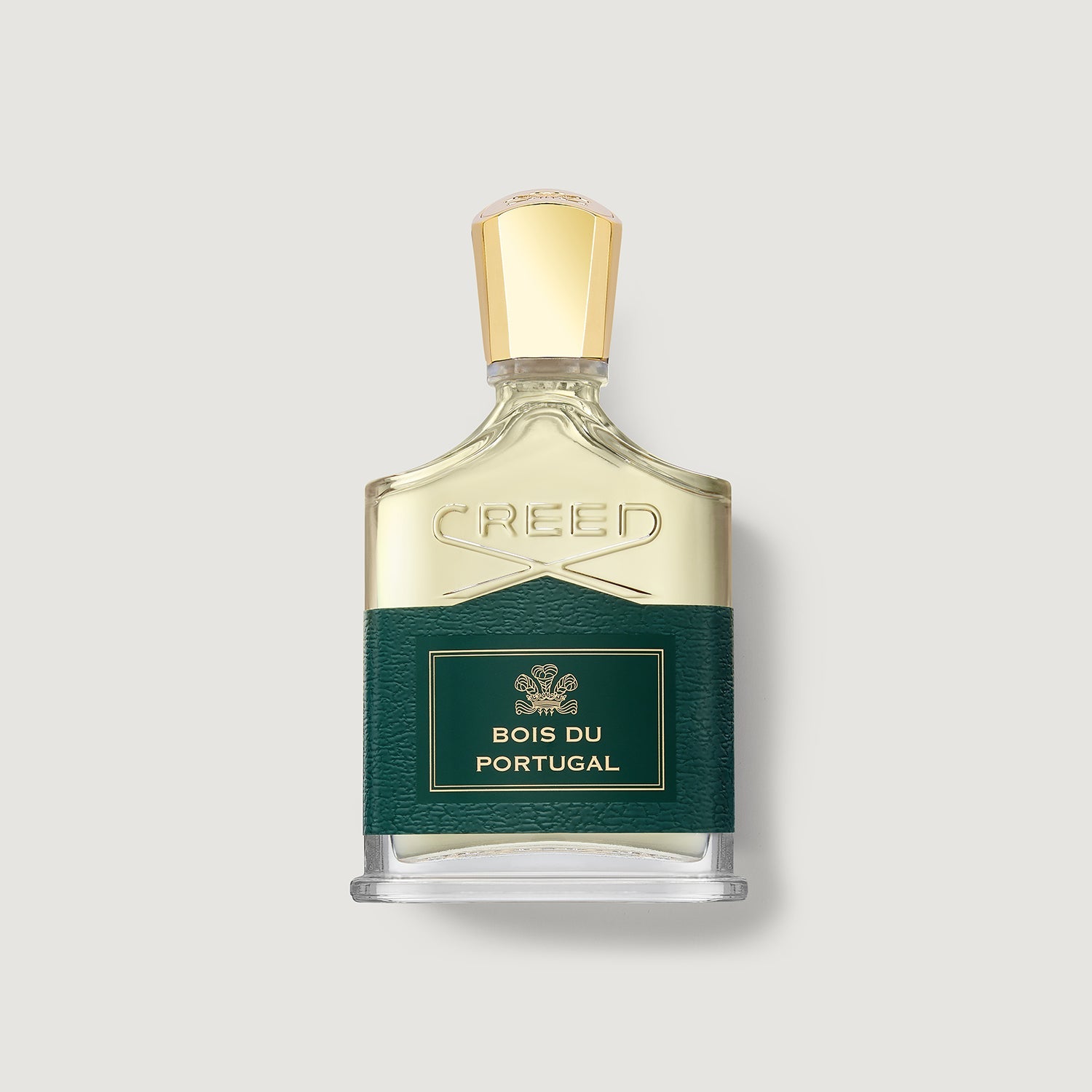 A bottle of Creed Bois du Portugal perfume, featuring a clear glass bottle with pale gold liquid, a textured dark green label with gold lettering, and a faceted gold cap, set against a light gray background.
