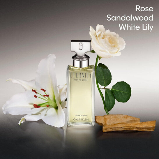 Calvin Klein Eternity perfume bottle with white lilies and sandalwood on a gray background