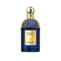Guerlain Patchouli Ardent perfume bottle in deep blue glass with a gold honeycomb-patterned cap and a gold label on a white background.