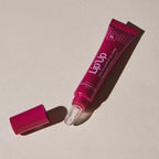 Pink 'Lip'Up' lip balm tube on a beige background