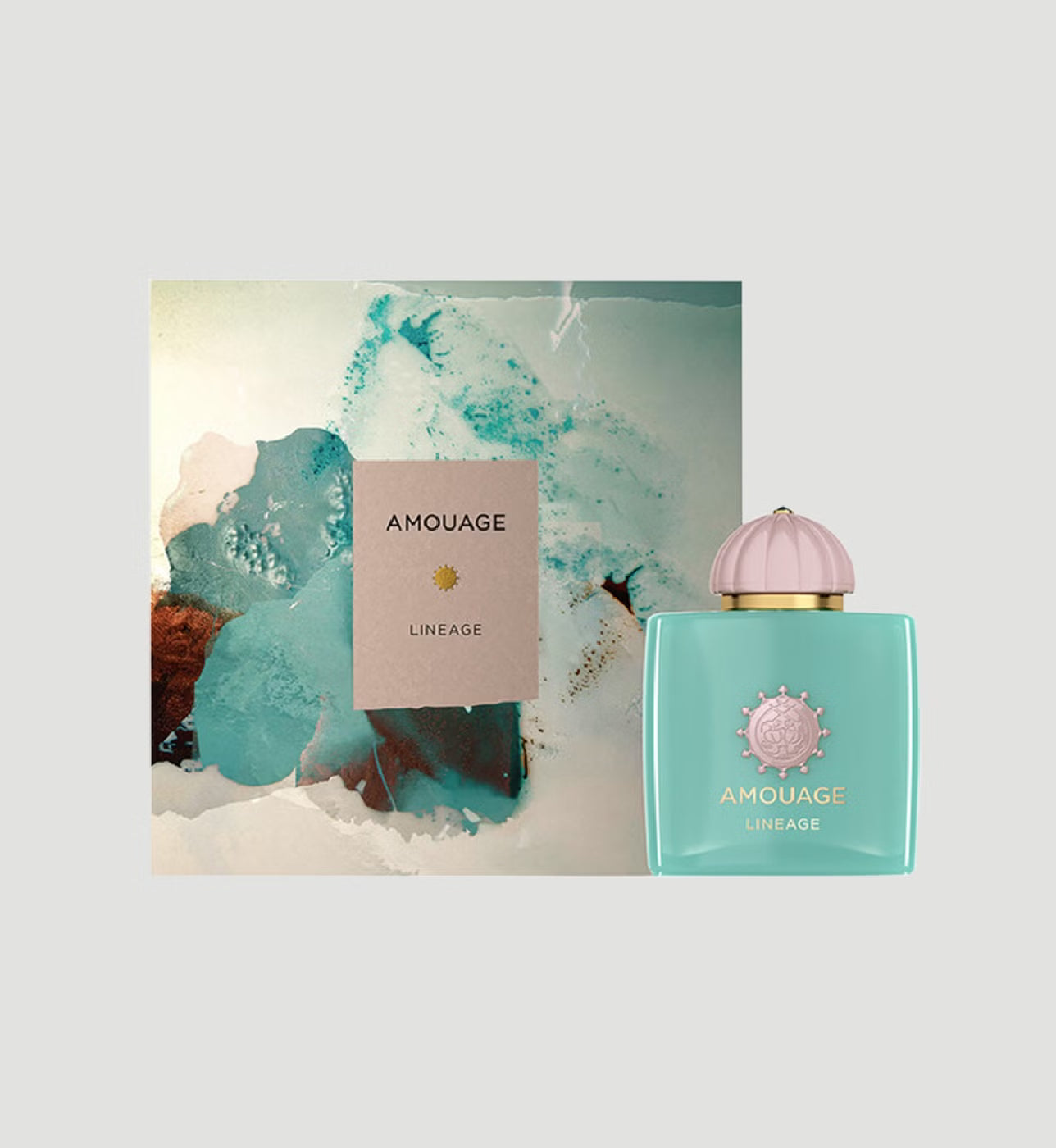 Amouage Lineage fragrance bottle in a light aqua color with a pink dome cap and gold lettering, shown next to its abstract art box on a light gray background.